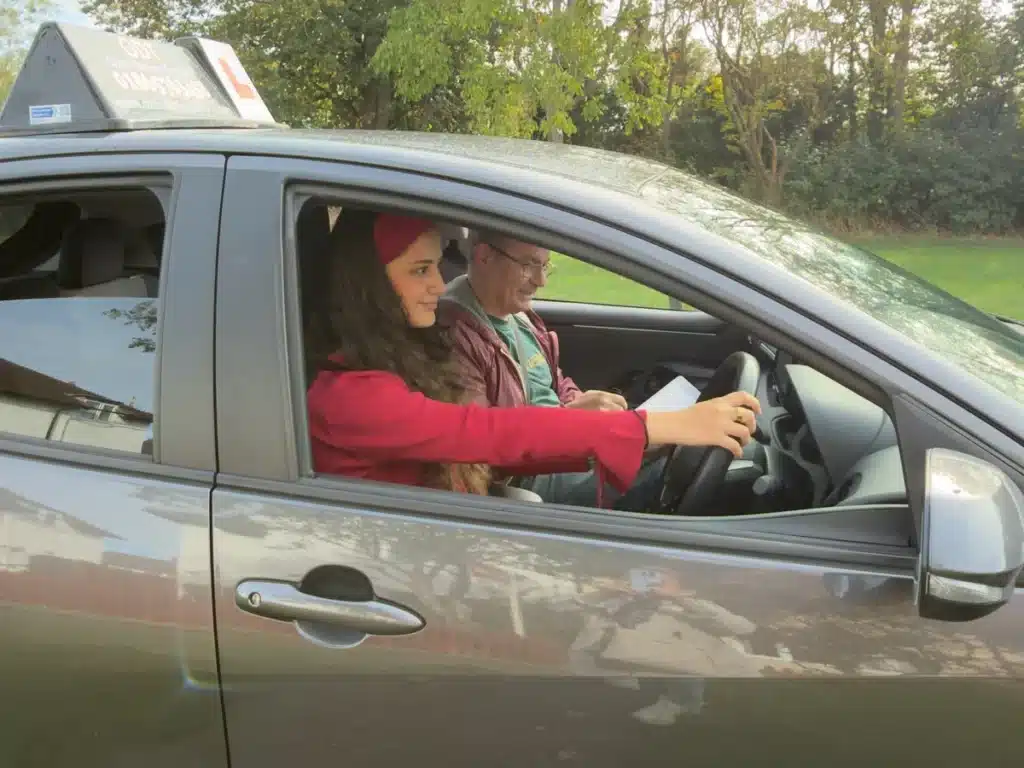 Learner driver at the wheel during a driving lesson in Oxford, with Oxon Driving Tuitions instructor Sam beside her