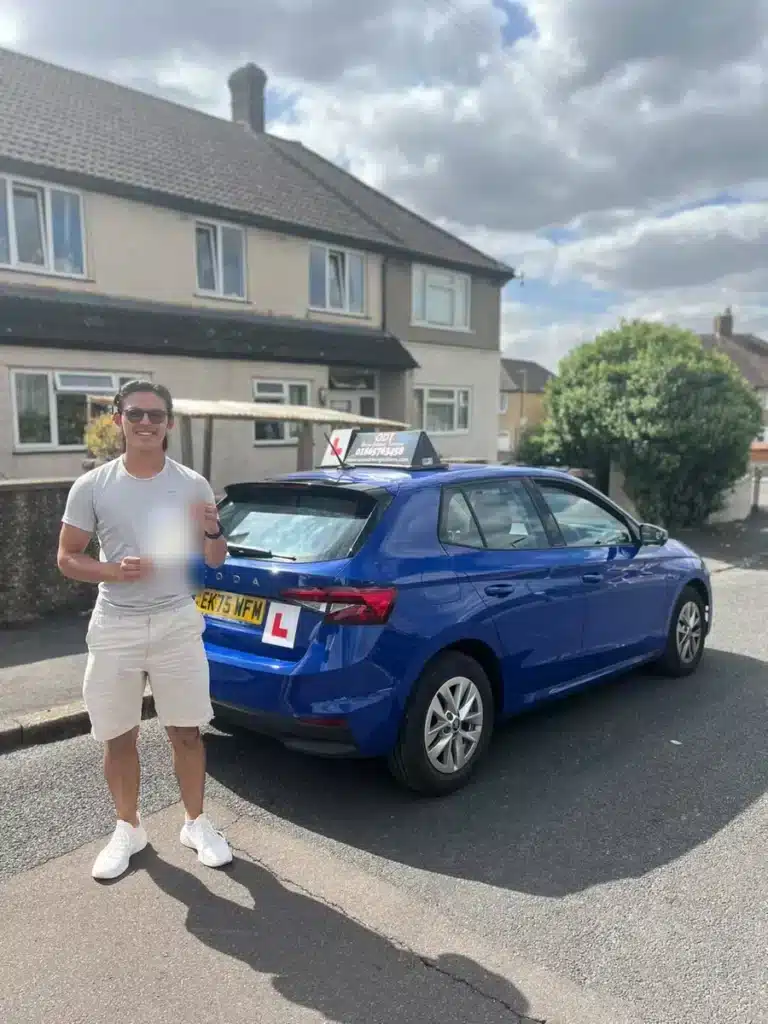 Learner driver smiling with his pass certificate next to an Oxon Driving Tuitions manual Skoda Fabia