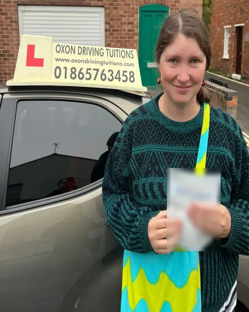 Jericho learner driver holding her driving test pass certificate beside an Oxon Driving Tuitions car