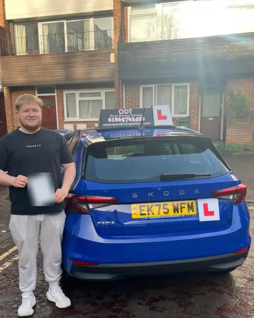 Headington learner driver holding his manual driving test pass certificate beside an Oxon Driving Tuitions manual Skoda Fabia