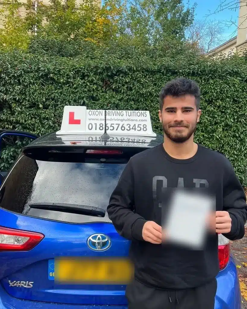 Marston learner driver holding his driving test pass certificate behind an Oxon Driving Tuitions automatic Toyota Yaris