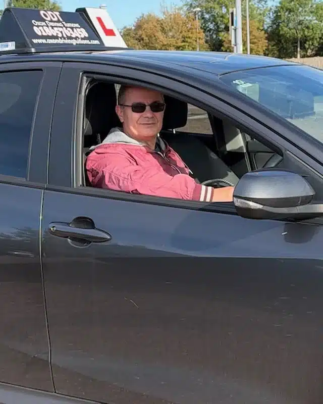 Sam Sam Sibachir, founder and automatic driving instructor at Oxon Driving Tuitions, in the driver seat of a tuition car